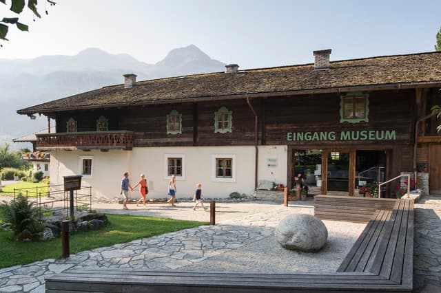 Un edificio tradizionale con la scritta "EINGANG MUSEUM". Si vedono visitatori che entrano nell’ingresso.