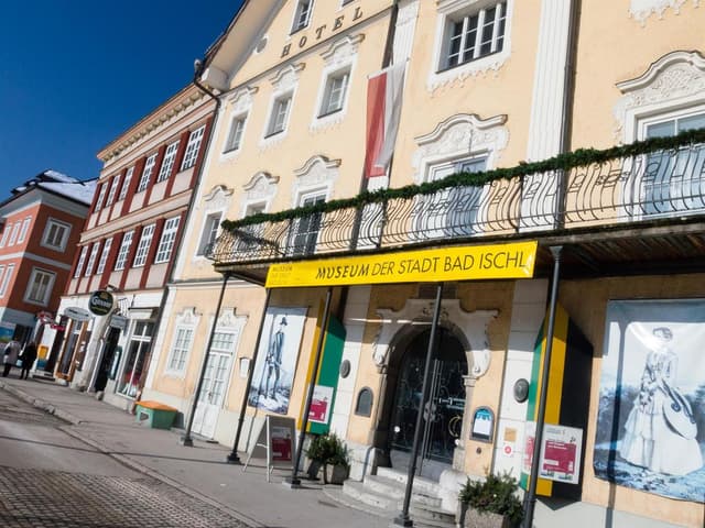 Historická budova se žlutou fasádou a balkonem. Je na ní zřetelně vidět Museum der Stadt Bad Ischl.