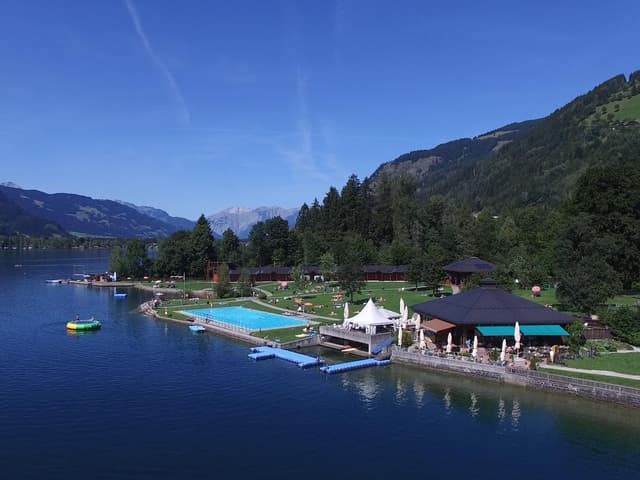Malebné jezero s bazénem a pěkným trávníkem. Obklopené zelenými horami a modrou oblohou, ideální k odpočinku.